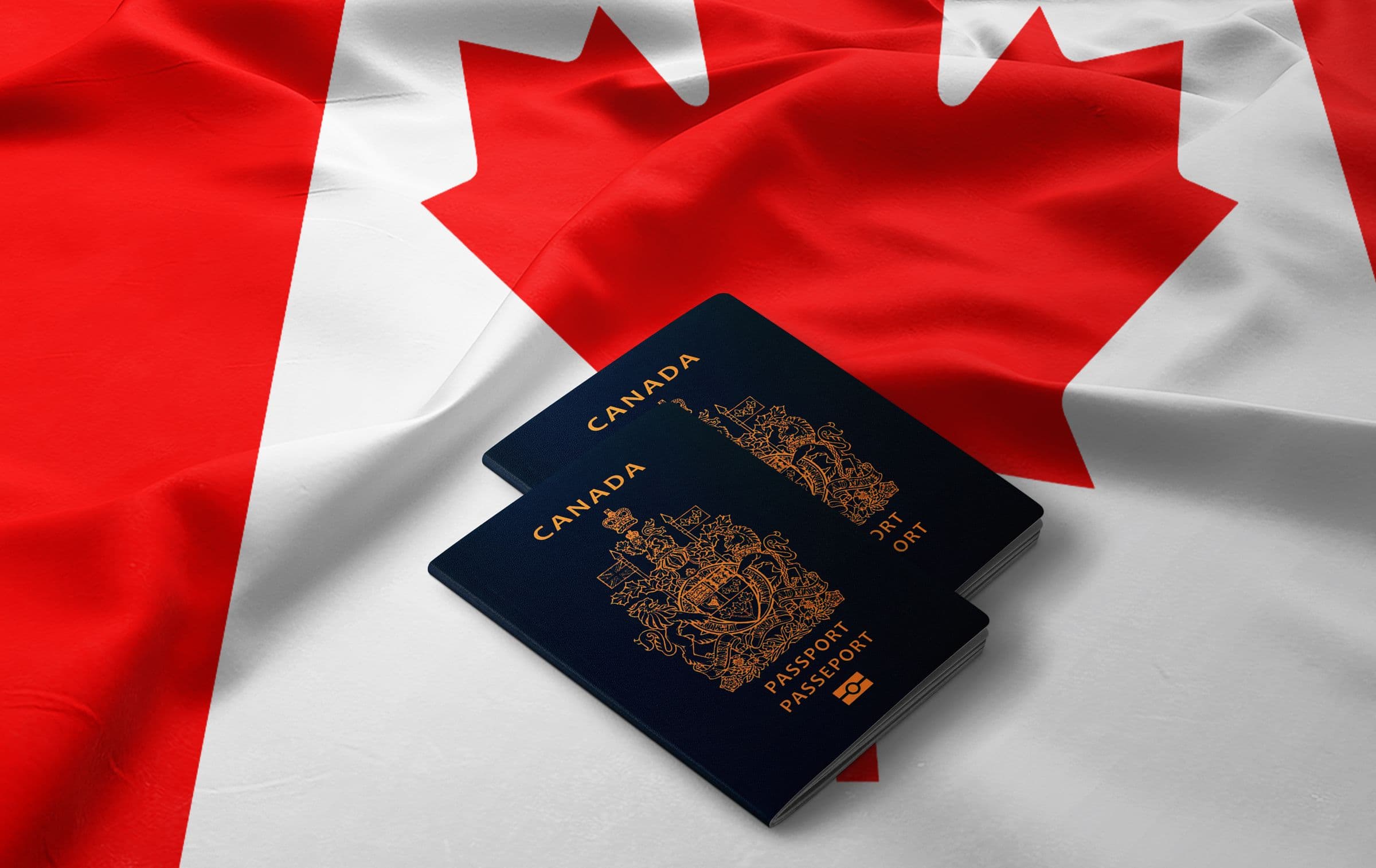 Two Canadian passports resting on a Canadian flag